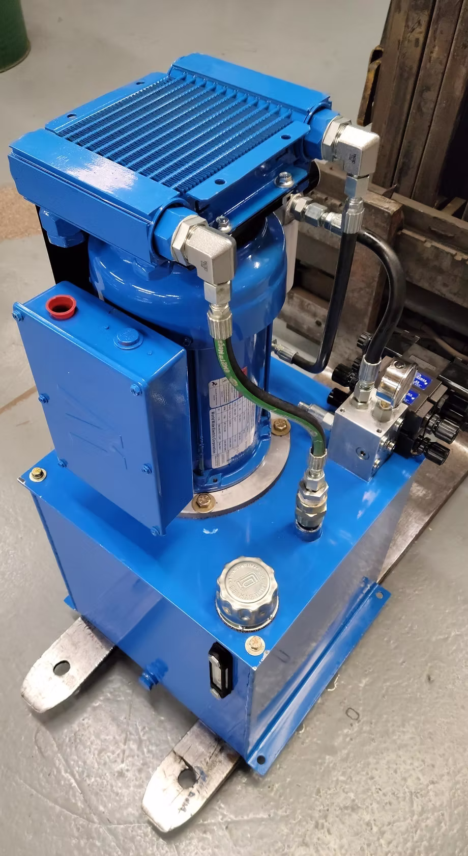 Blue hydraulic power unit with complex piping and metal connectors